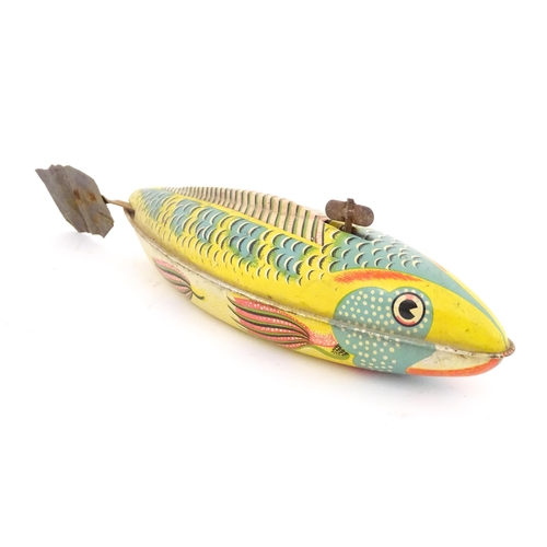 830 - Toy: A 20thC lithographed tinplate clockwork model fish. Marked Made in Great Britain under. Approx.... 