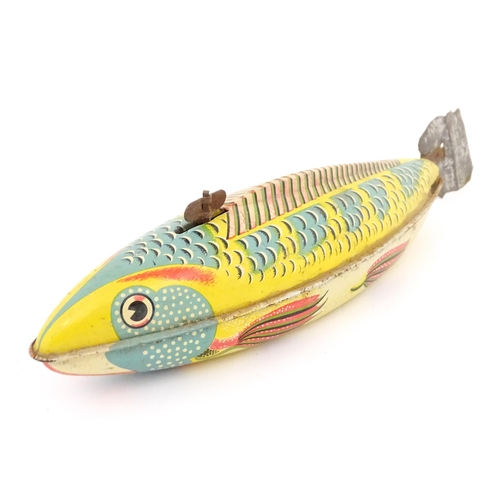 830 - Toy: A 20thC lithographed tinplate clockwork model fish. Marked Made in Great Britain under. Approx.... 