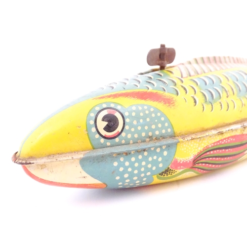 830 - Toy: A 20thC lithographed tinplate clockwork model fish. Marked Made in Great Britain under. Approx.... 