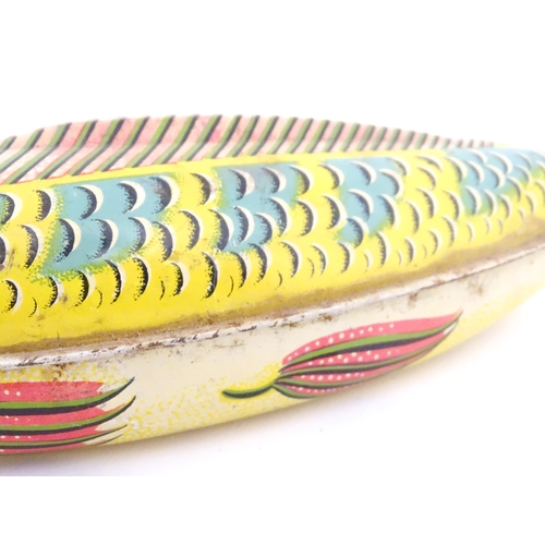 830 - Toy: A 20thC lithographed tinplate clockwork model fish. Marked Made in Great Britain under. Approx.... 