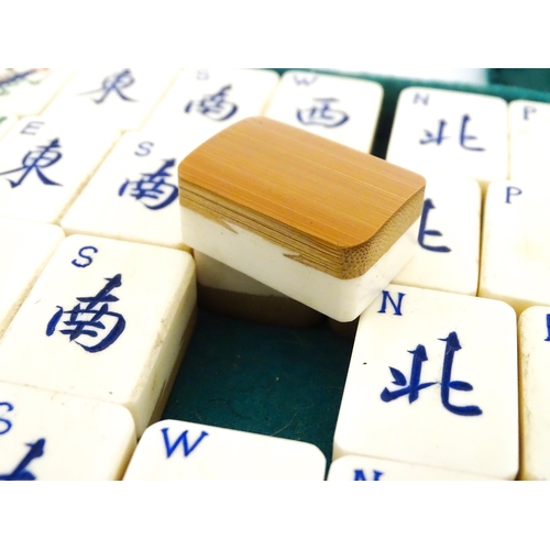 833 - Toys: A 20thC Chinese bone and bamboo Mahjong set within a leather case with five lift out trays. To... 