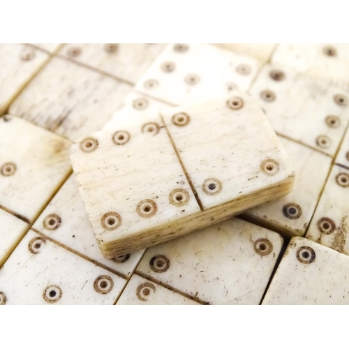 835 - Toys: A quantity of 19thC prisoner of war carved bone dominoes within a wooden box of book form. Dom... 