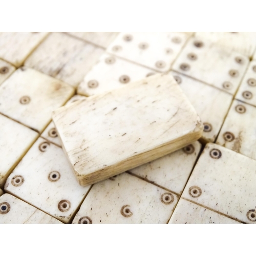 835 - Toys: A quantity of 19thC prisoner of war carved bone dominoes within a wooden box of book form. Dom... 