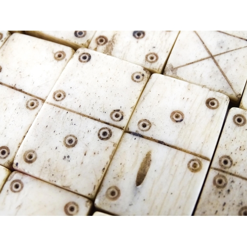 835 - Toys: A quantity of 19thC prisoner of war carved bone dominoes within a wooden box of book form. Dom... 