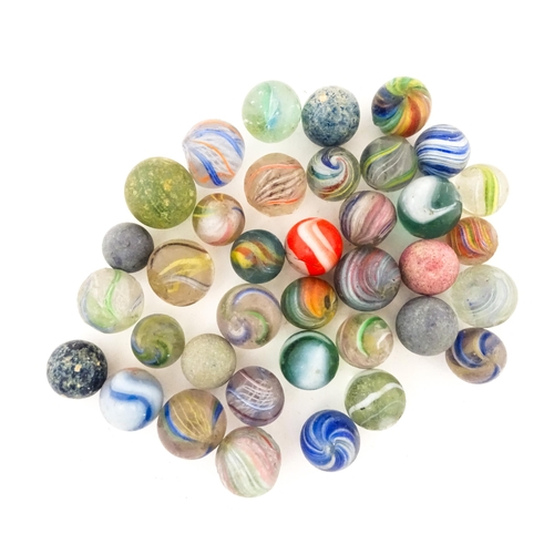 836 - Toys: A quantity of assorted vintage marbles, many with colours twists, etc. Contained within a Cadb... 