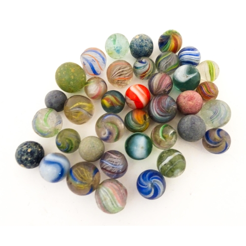 836 - Toys: A quantity of assorted vintage marbles, many with colours twists, etc. Contained within a Cadb... 