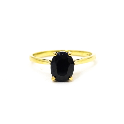 703 - A 9ct gold ring set with central sapphire. Together with matching earrings. Ring size approx. N