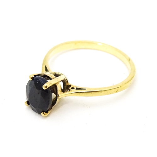 703 - A 9ct gold ring set with central sapphire. Together with matching earrings. Ring size approx. N