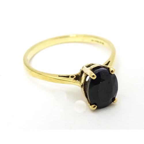 703 - A 9ct gold ring set with central sapphire. Together with matching earrings. Ring size approx. N