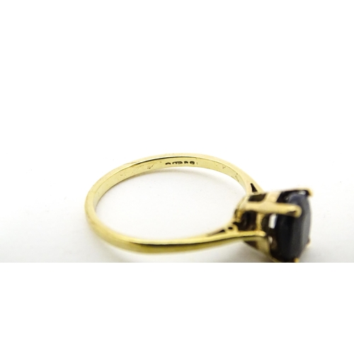 703 - A 9ct gold ring set with central sapphire. Together with matching earrings. Ring size approx. N