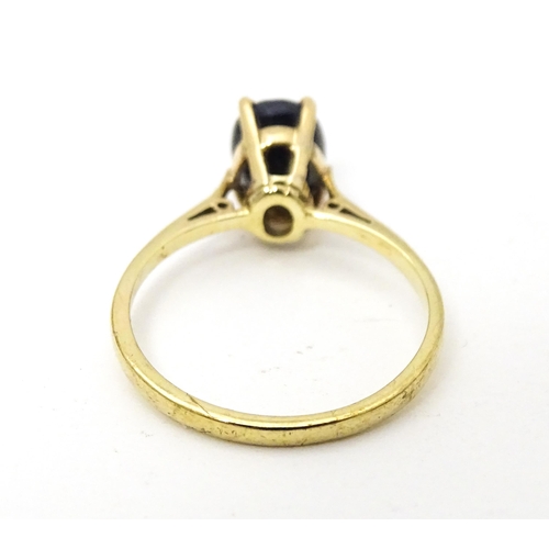 703 - A 9ct gold ring set with central sapphire. Together with matching earrings. Ring size approx. N