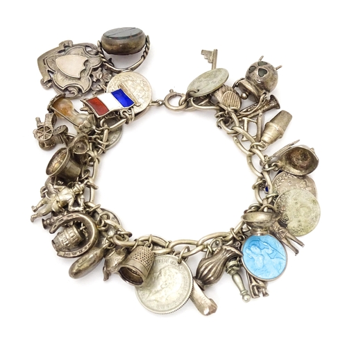 706 - A silver charm bracelet set with a quantity of assorted silver, white metal and silver plate charms,... 