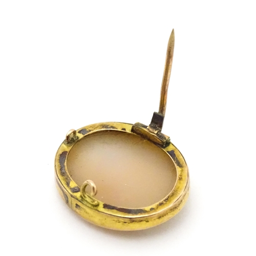 708 - A Classical shell carved cameo within a yellow metal surround. Together with a locket formed pendant... 