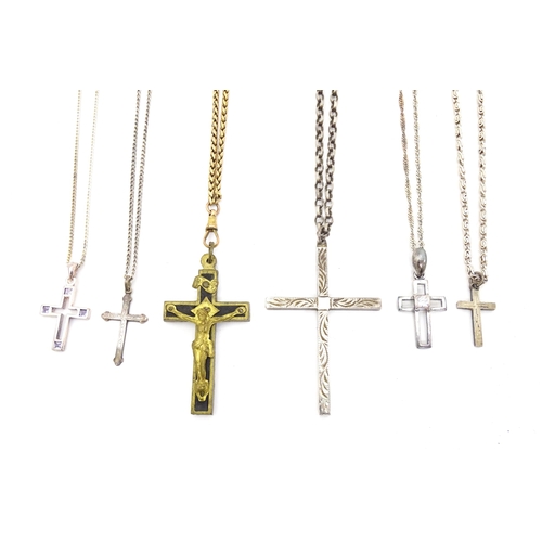 710 - Six assorted cross / cruciform pendants on chains, to include some silver examples. Largest pendant ... 