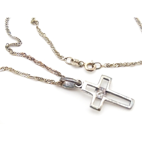 710 - Six assorted cross / cruciform pendants on chains, to include some silver examples. Largest pendant ... 