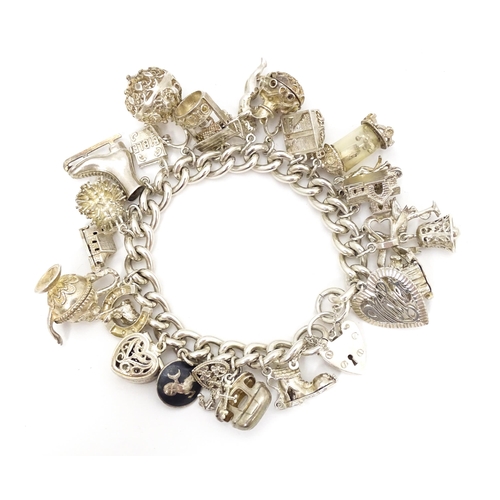 726 - A silver charm bracelet set with a large quantity of assorted silver, white metal and silver plate c... 