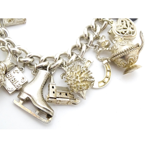 726 - A silver charm bracelet set with a large quantity of assorted silver, white metal and silver plate c... 