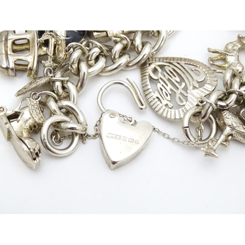 726 - A silver charm bracelet set with a large quantity of assorted silver, white metal and silver plate c... 