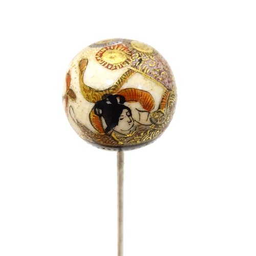 733 - A hat pin surmounted by a Japanese satsuma cabochon.