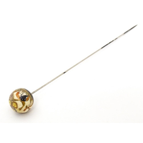 733 - A hat pin surmounted by a Japanese satsuma cabochon.