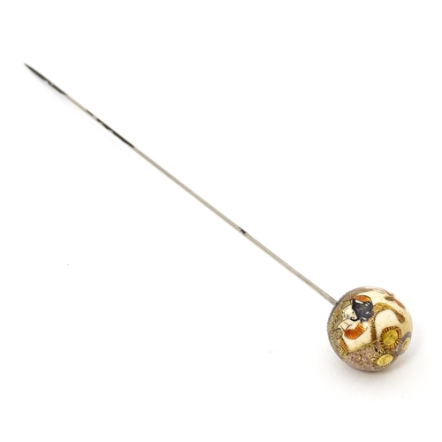 733 - A hat pin surmounted by a Japanese satsuma cabochon.