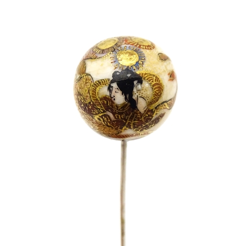 733 - A hat pin surmounted by a Japanese satsuma cabochon.