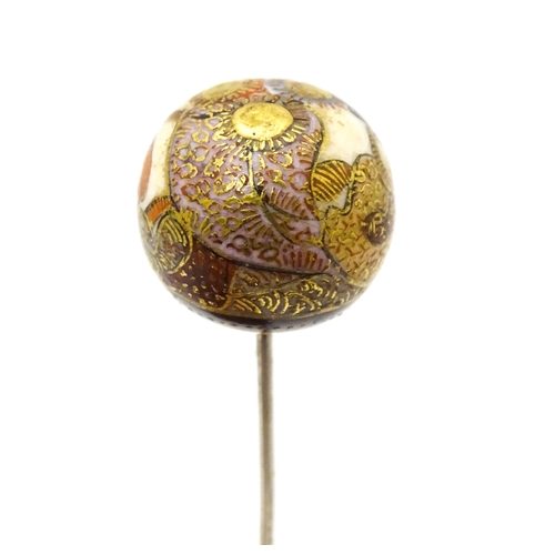 733 - A hat pin surmounted by a Japanese satsuma cabochon.