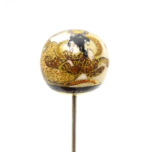 733 - A hat pin surmounted by a Japanese satsuma cabochon.