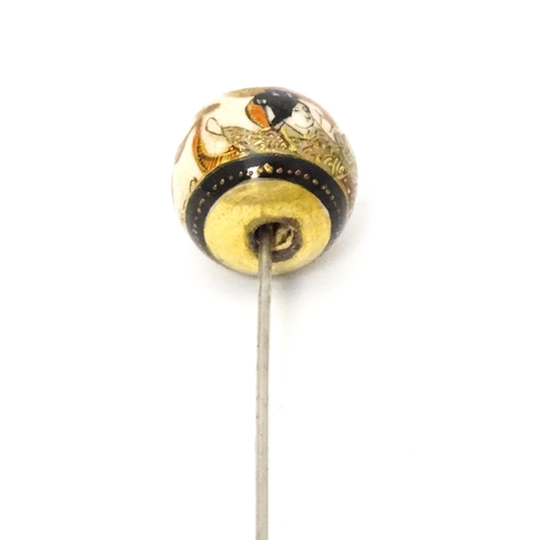 733 - A hat pin surmounted by a Japanese satsuma cabochon.