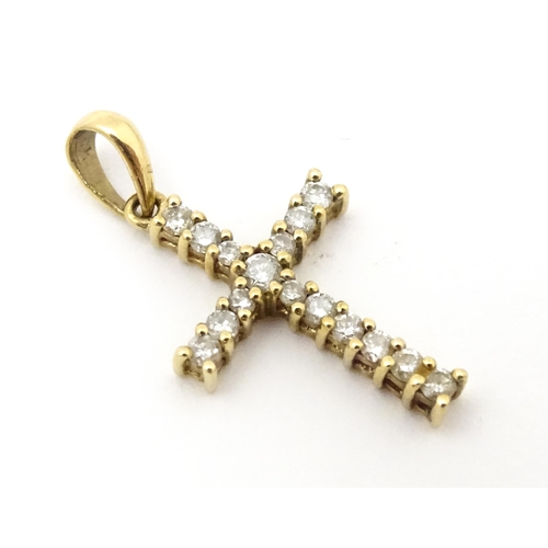 735 - A 9ct gold cross form pendant set with diamonds. Approx. 1