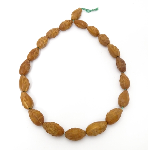 739 - An Oriental necklace of Hediao carved nut beads. Approx. 23