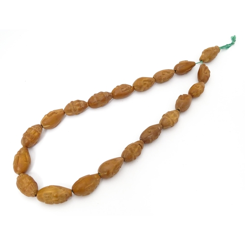 739 - An Oriental necklace of Hediao carved nut beads. Approx. 23