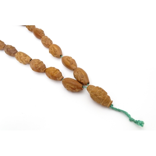 739 - An Oriental necklace of Hediao carved nut beads. Approx. 23