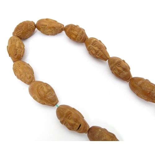 739 - An Oriental necklace of Hediao carved nut beads. Approx. 23