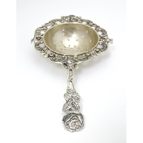 337 - A Continental .835 silver tea / lemon strainer with floral detail to handle. Approx. 5 1/2