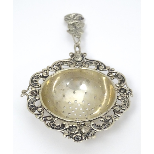 337 - A Continental .835 silver tea / lemon strainer with floral detail to handle. Approx. 5 1/2