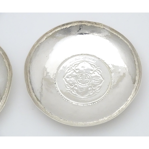 341 - A pair of white metal pin dishes with hammered decoration and inset coin medallions to base. Possibl... 