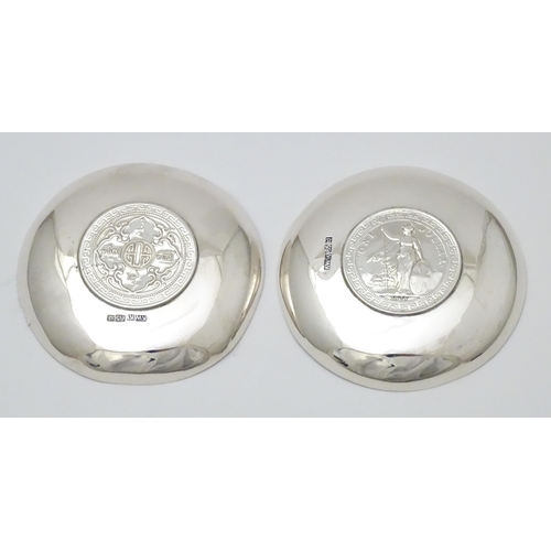 341 - A pair of white metal pin dishes with hammered decoration and inset coin medallions to base. Possibl... 