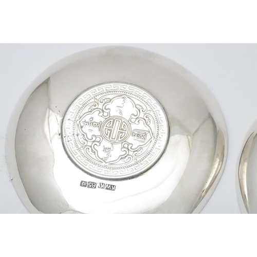 341 - A pair of white metal pin dishes with hammered decoration and inset coin medallions to base. Possibl... 