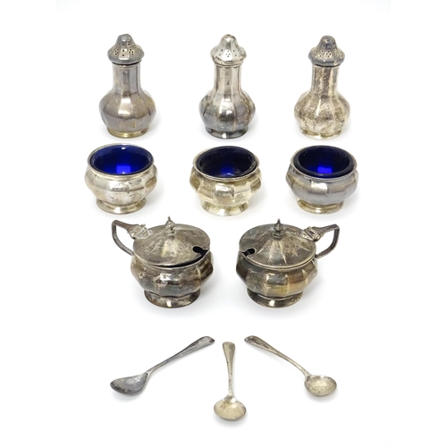 411 - A matched eight piece silver cruet comprising three pepperettes, three salts with blue glass liners,... 