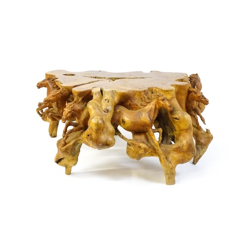 1328 - A mid 20thC root carved coffee table, with galloping horses populating the exterior of the table and... 