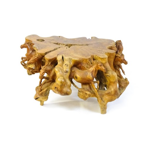 1328 - A mid 20thC root carved coffee table, with galloping horses populating the exterior of the table and... 