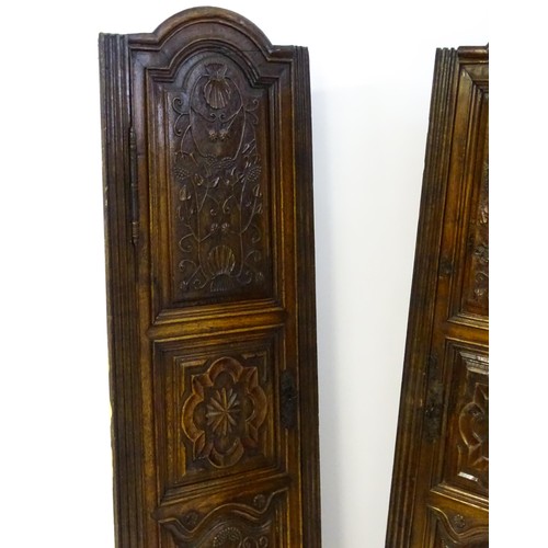 1339 - A pair of 19thC carved oak cupboards with rounded tops, panelled doors, fluted pilasters and having ... 