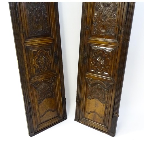 1339 - A pair of 19thC carved oak cupboards with rounded tops, panelled doors, fluted pilasters and having ... 