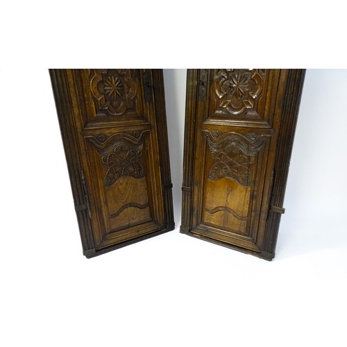 1339 - A pair of 19thC carved oak cupboards with rounded tops, panelled doors, fluted pilasters and having ... 