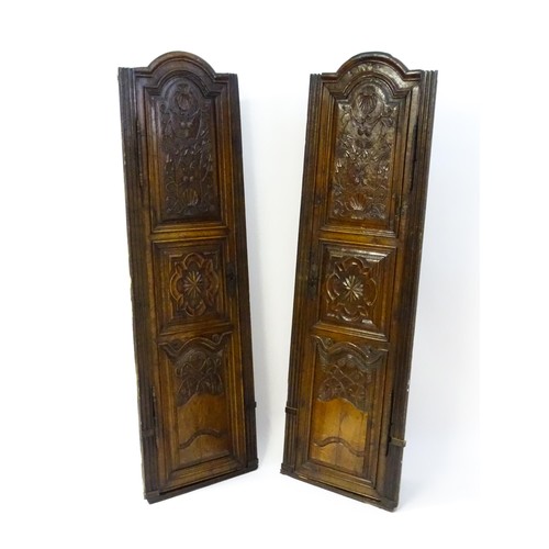 1339 - A pair of 19thC carved oak cupboards with rounded tops, panelled doors, fluted pilasters and having ... 