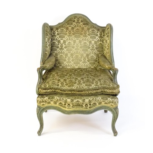 1340 - An early 20thC fauteuil wingback armchair, with a shaped top rail above scrolled arms and raised on ... 