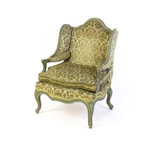 1340 - An early 20thC fauteuil wingback armchair, with a shaped top rail above scrolled arms and raised on ... 