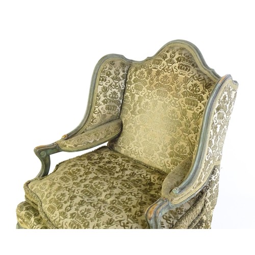 1340 - An early 20thC fauteuil wingback armchair, with a shaped top rail above scrolled arms and raised on ... 