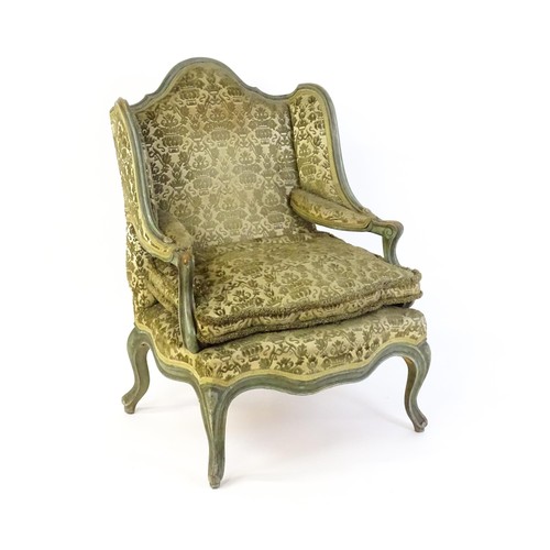 1340 - An early 20thC fauteuil wingback armchair, with a shaped top rail above scrolled arms and raised on ... 